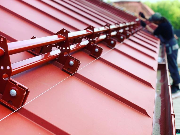 Snow guards for standing seam metal roofs