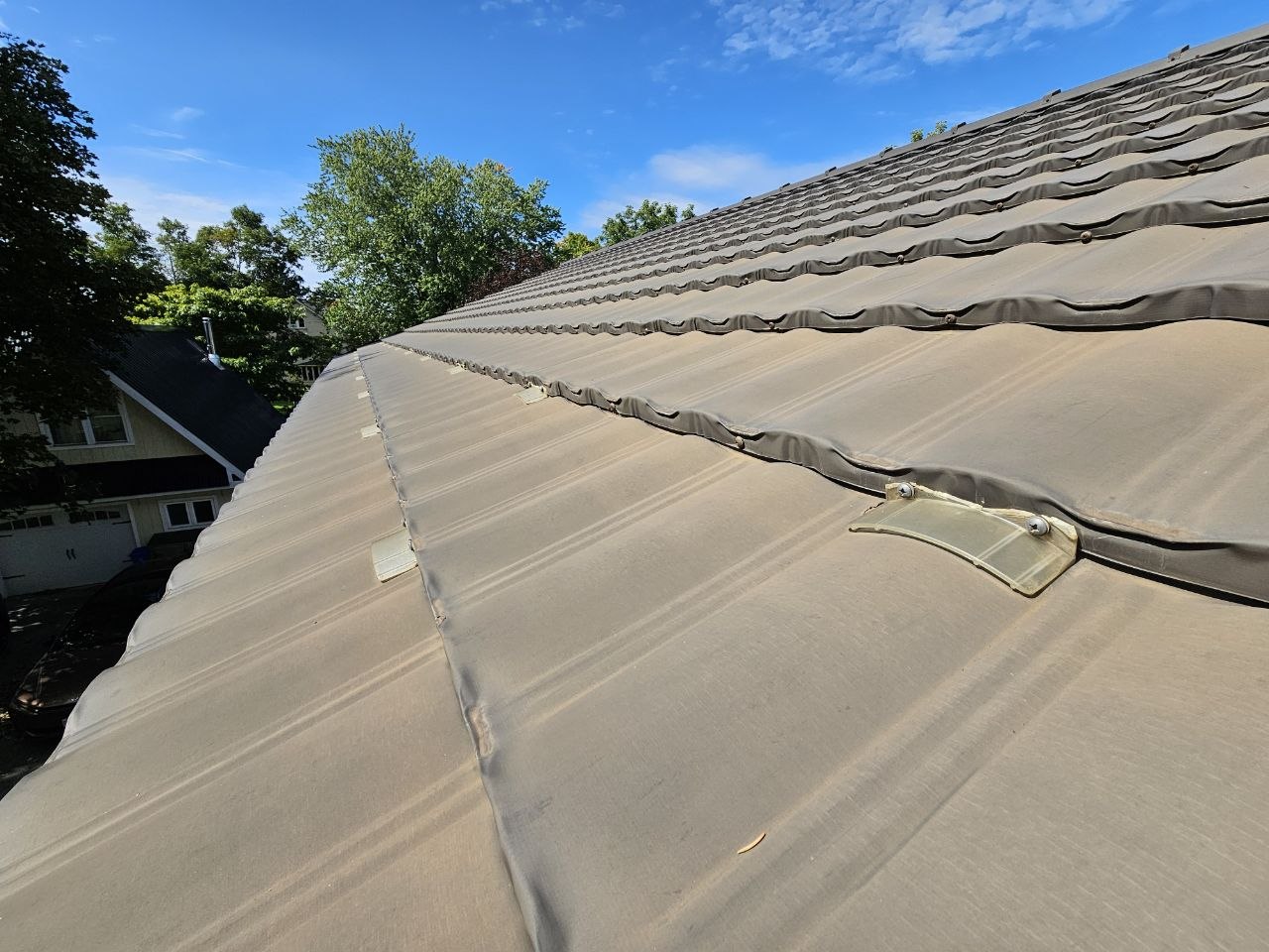 Broken individual plastic snow guards on metal tile roof, Uxbridge Ontario