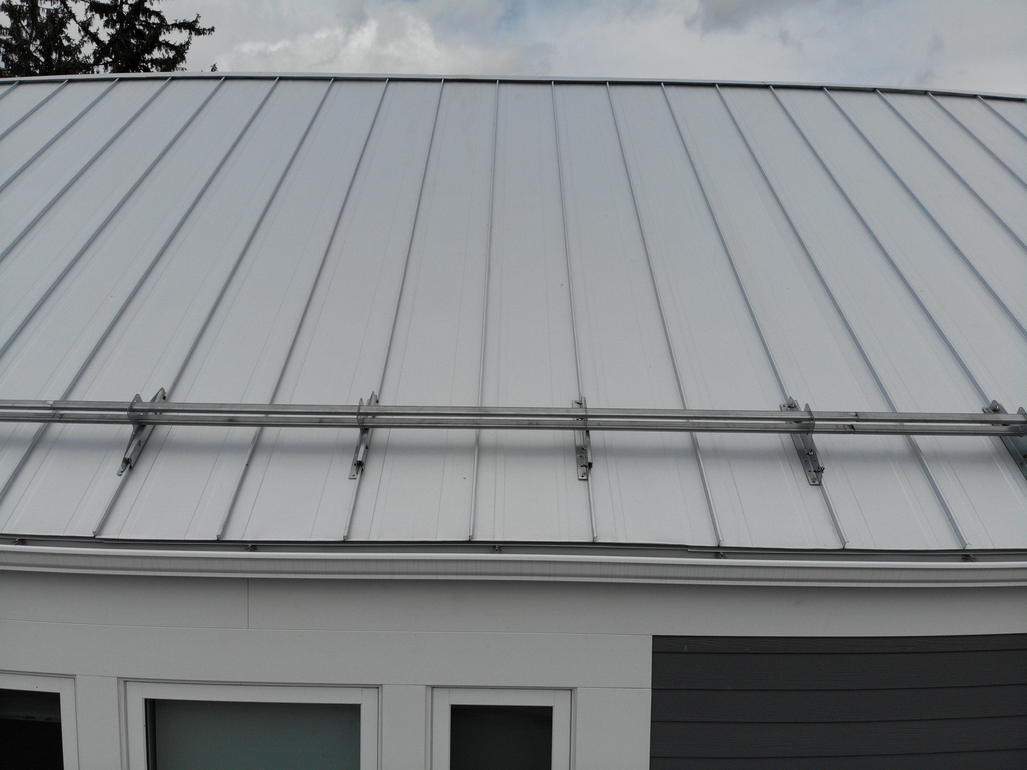 Snow guard row on Galvalume standing seam roof, North York Toronto residential project
