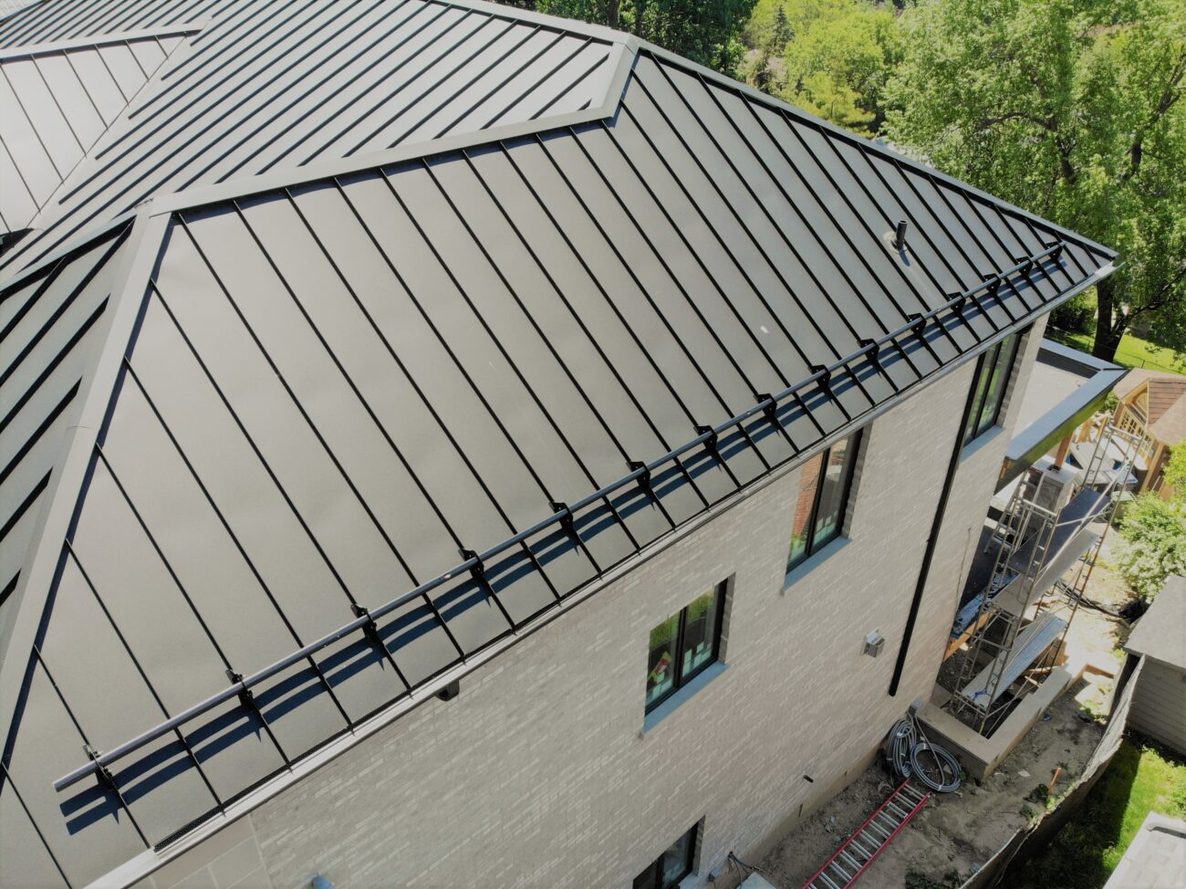 Black snow guard clamp detail on snap-lock standing seam roof, Scarborough Toronto
