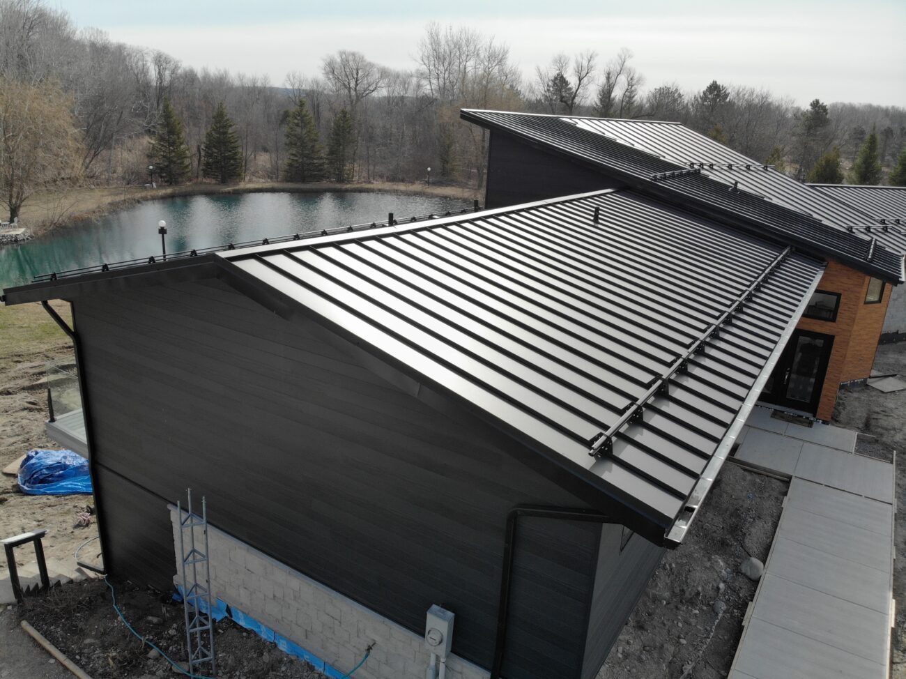 Steel tubular snow guards on black snap-lock standing seam roof in Uxbridge, Ontario