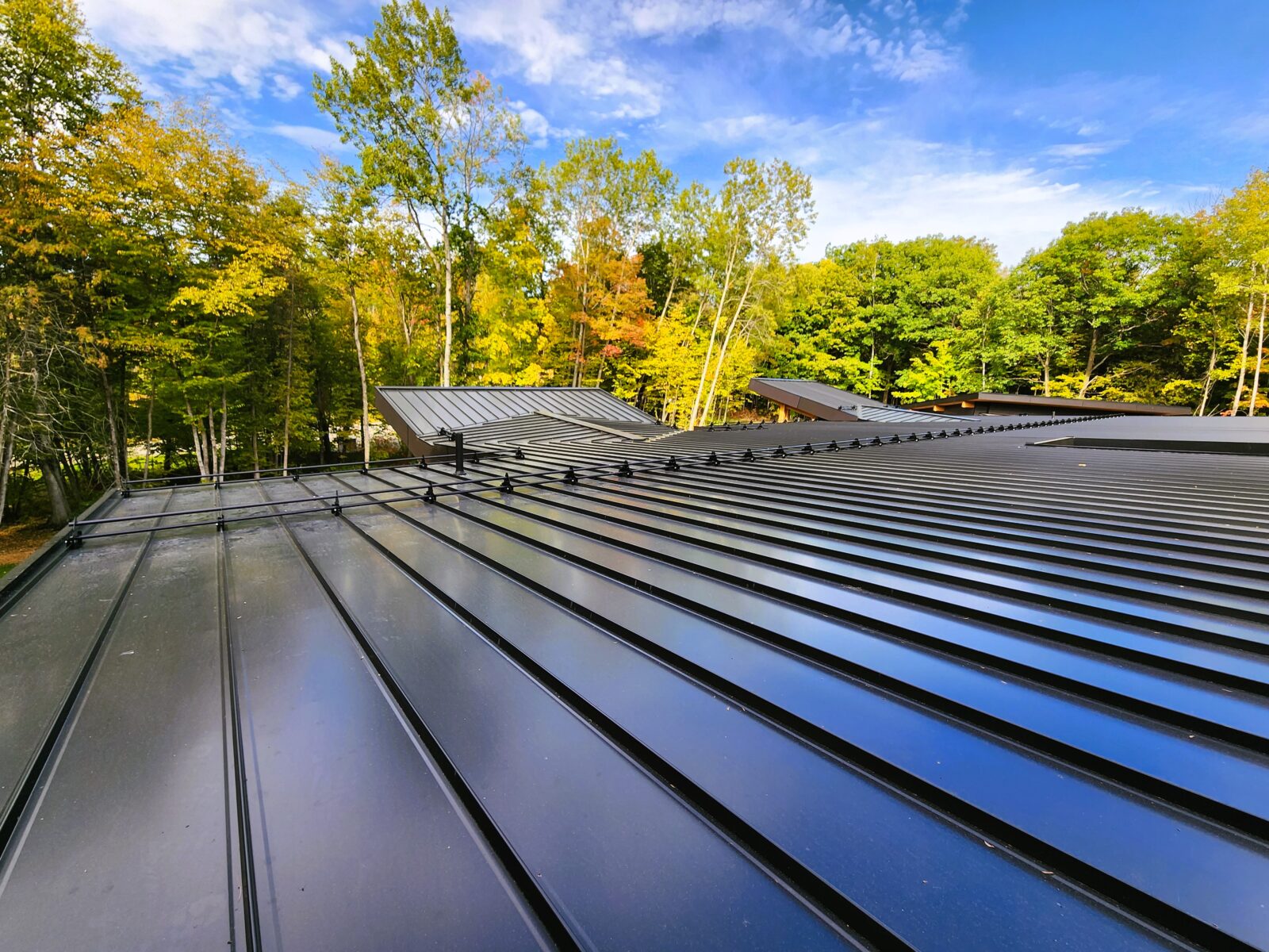 Black snap-lock standing seam metal roof on residential property in Muskoka, Ontario