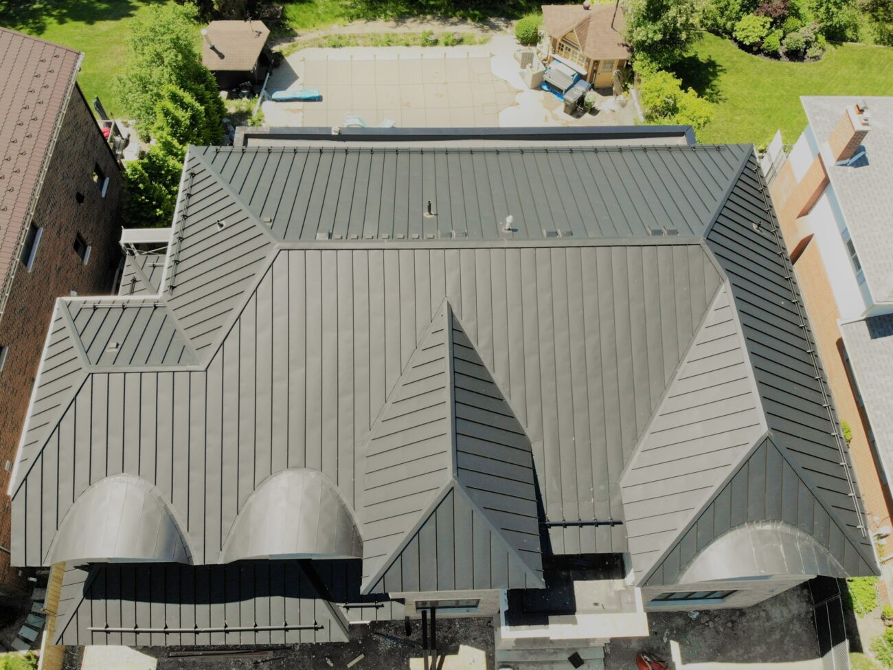 Black snap-lock standing seam metal roof on new residential build in Scarborough, Toronto