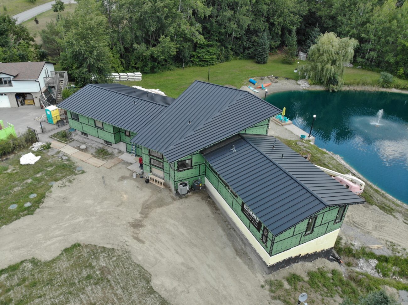Black snap-lock standing seam metal roof on residential property in Uxbridge, Ontario