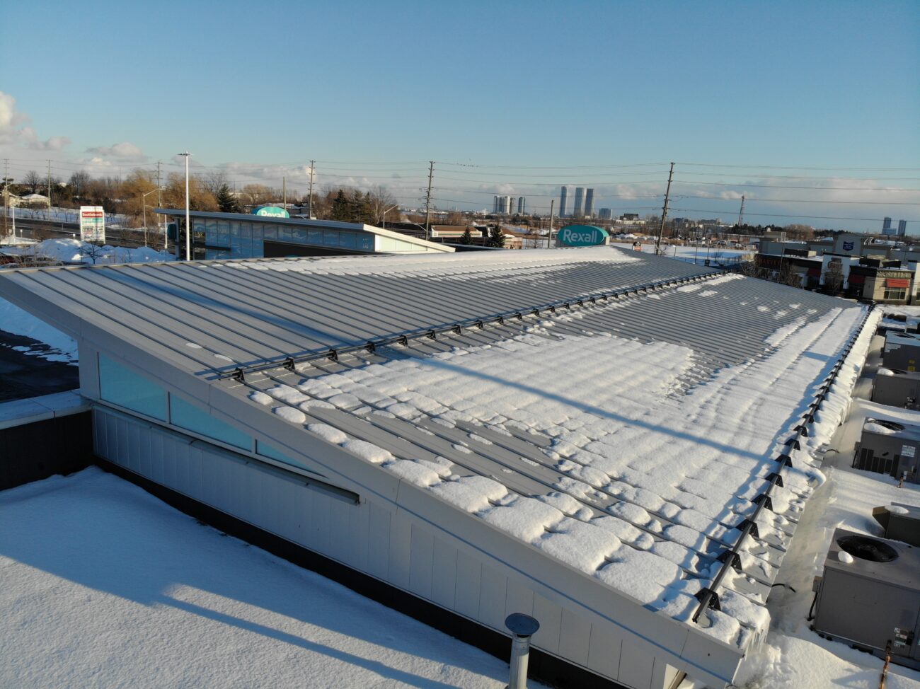 Snap-lock standing seam metal roof on commercial plaza in Vaughan, Ontario — grey panels
