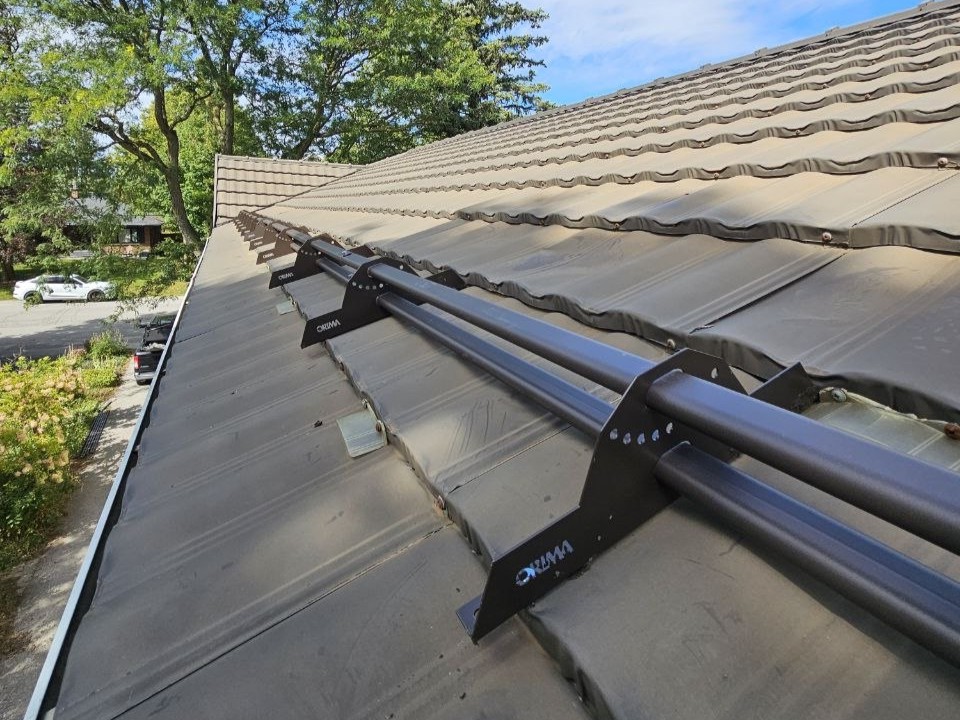 Tubular versus plastic snow guards comparison on metal tile roof, Ontario